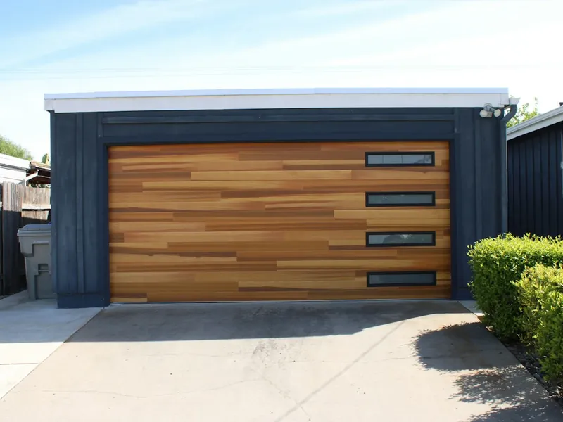 Newly installed wood-look modern garage door with window strip