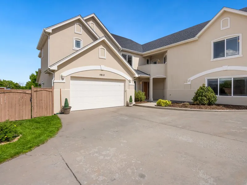 Two-story stucco home with an arched white garage door in Santee